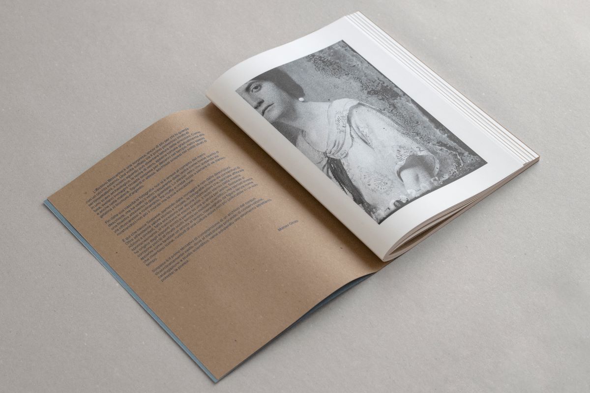 Foto di un libro aperto, con in una pagina il ritratto fotografico in bianco e nero di una donna.