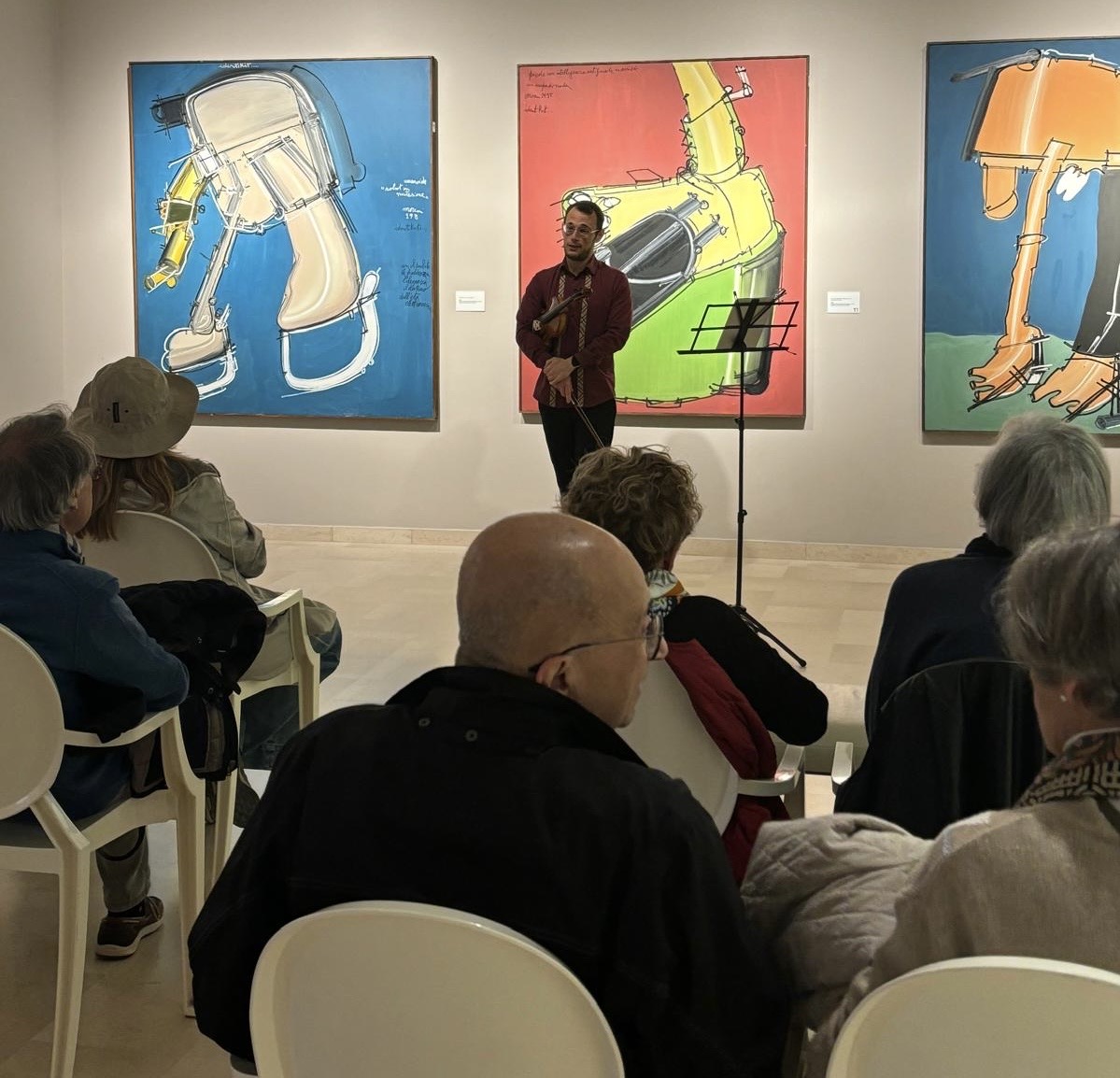 sala della mostra dedicata a Moreni con visitatori e lusicista